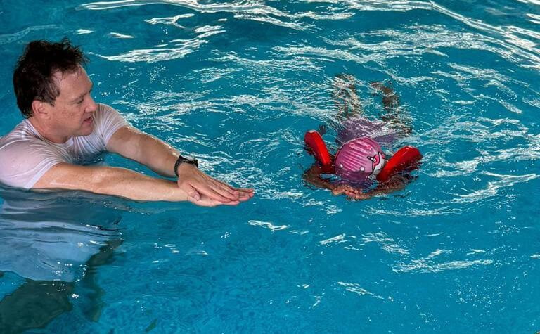Paul teaching child to swim